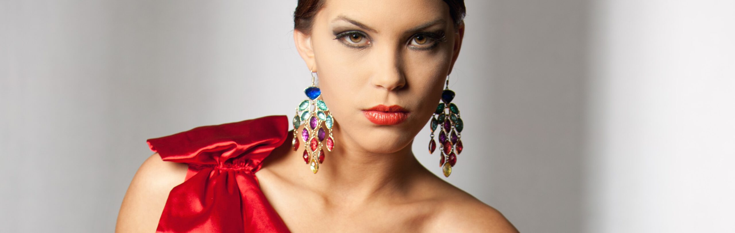 Make-up-Styling mit auffälligem Schmuck und rotem Kleid